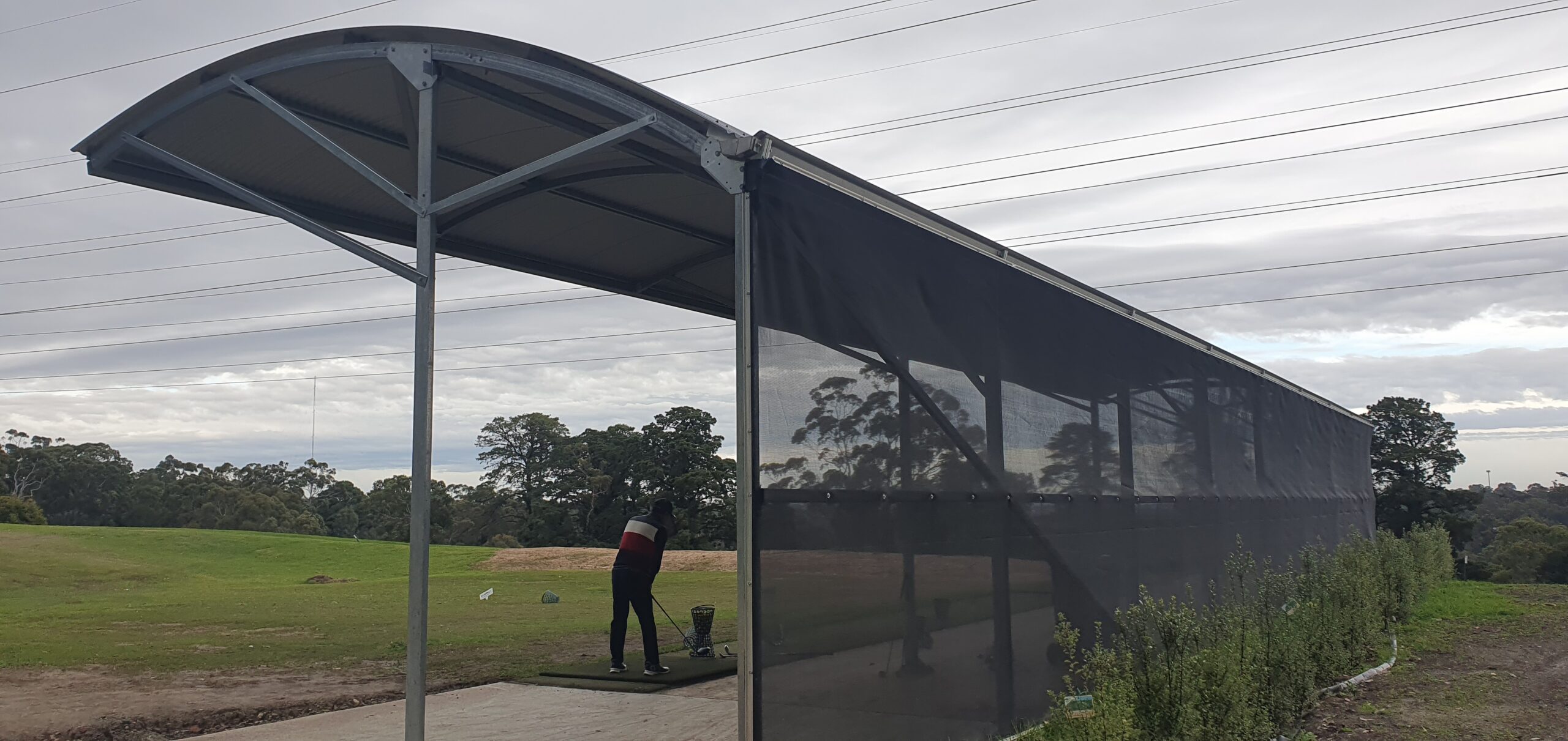 Covered golf tee with a golfer facing the left preparing to hit the ball