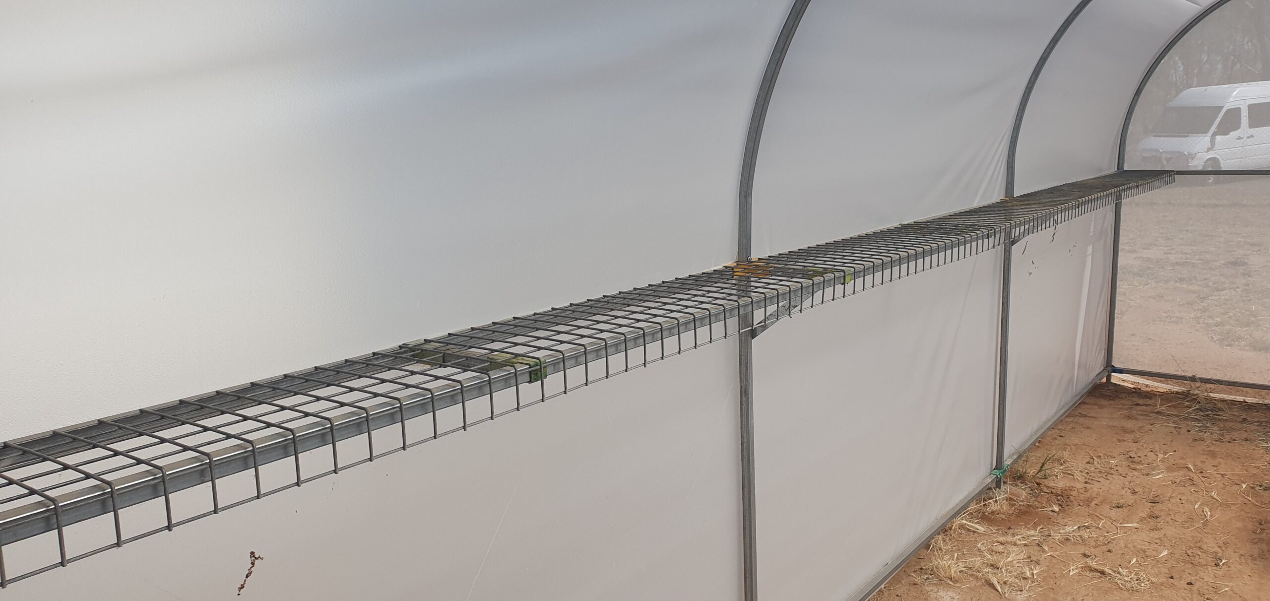 Closeup view of side railing from interior of domestic greenhouse