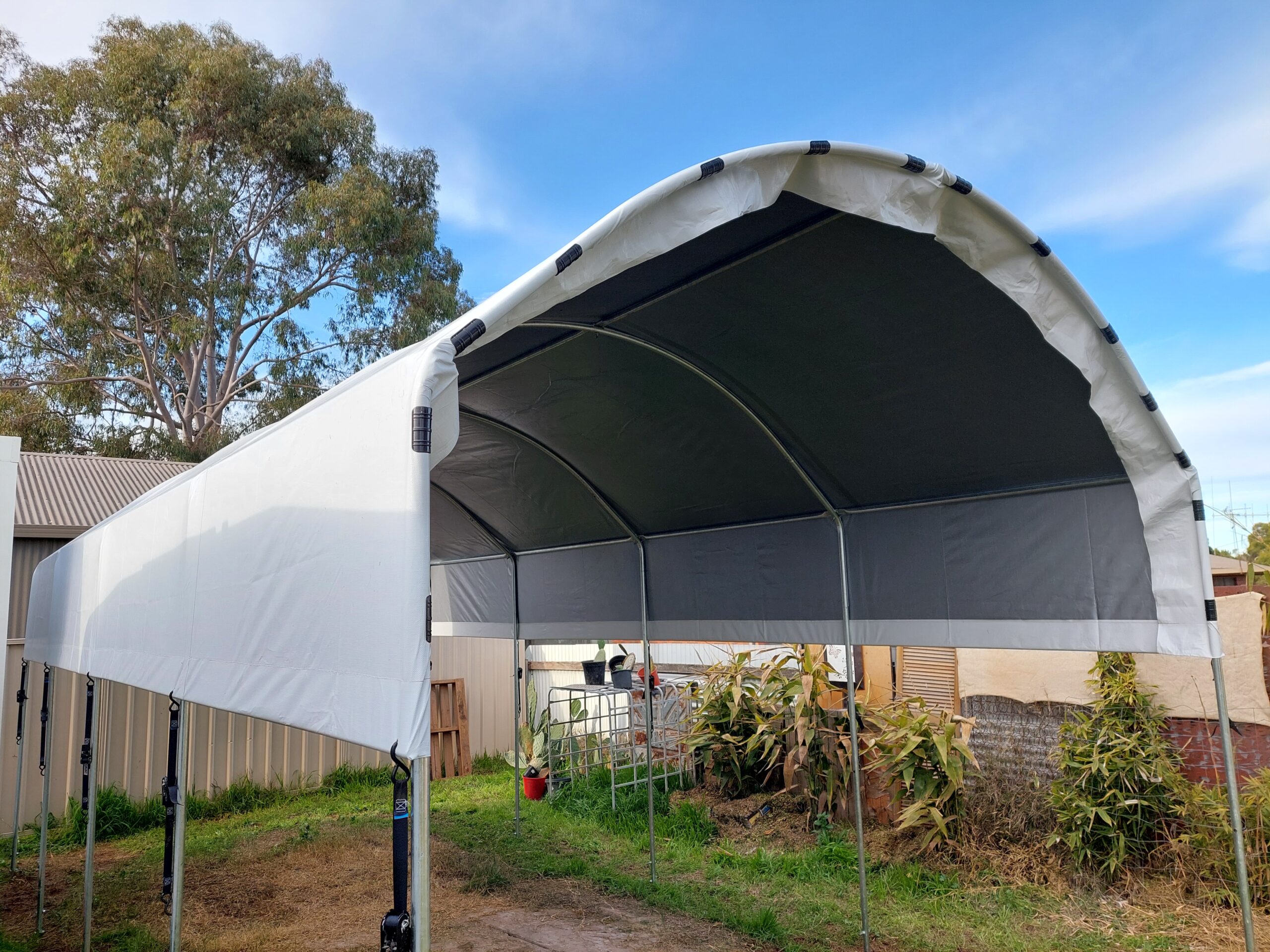 Large white caravan shelter sitting on top of the ground